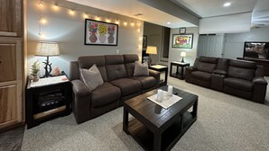 A living room with two brown sofas, a coffee table, and a TV. There are string lights on the ceiling and artwork on the walls. - 3 Dog Night (Vacation Rental) Private. 7 min to T.I.E.C (Mill Spring)