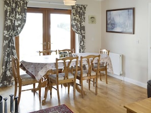 A dining area with a wooden table and chairs, a radiator, and a framed picture on the wall.