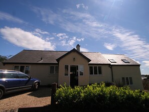 A two-story house with a front entrance, a driveway, and a parked car.
