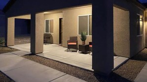 A covered patio area with a seating arrangement and a potted plant.