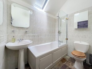 Ein Badezimmer mit Badewanne, Waschbecken, Toilette und einer Duschkabine aus Glas.