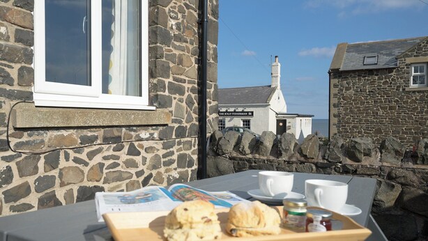 A stone building with a sign reading "The Jolly Fisherman." - 2 bedroom accommodation in Craster (Craster)
