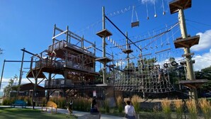 Ein Outdoor-Abenteuerparcours mit Seilbrücken, Holzplattformen und einem Netzparcours.