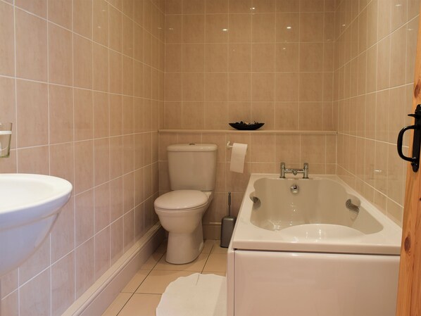 Une salle de bain équipée de toilettes, d’un lavabo et d’une baignoire.