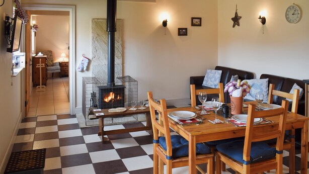 A cozy living room with a fireplace, wooden furniture, and a checkered floor. - 2 bedroom accommodation in Easby Grange, near Great Ayton (Easby Grange, near Great Ayton)