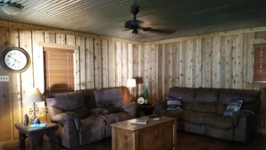 A cozy living room with two sofas, a coffee table, a lamp, and a clock on the wall. - Lake Front Gated Property  Private Dock 
Book 3 Nights - Get 4th Night Free.  (Wills Point)