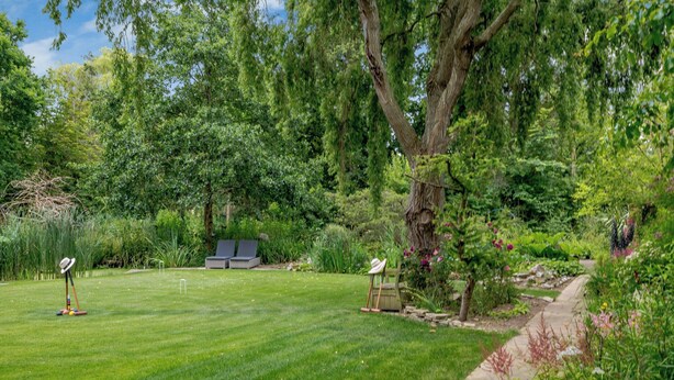A well-maintained lawn with a lawnmower, a pair of lounge chairs, and a picnic table. - 5 bedroom accommodation in Ludham (Ludham)
