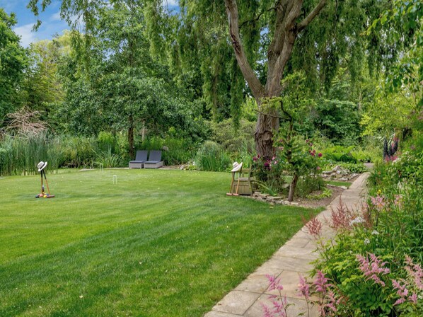 A well-maintained lawn with a lawnmower, a pair of lounge chairs, and a picnic table. - 5 bedroom accommodation in Ludham (Ludham)