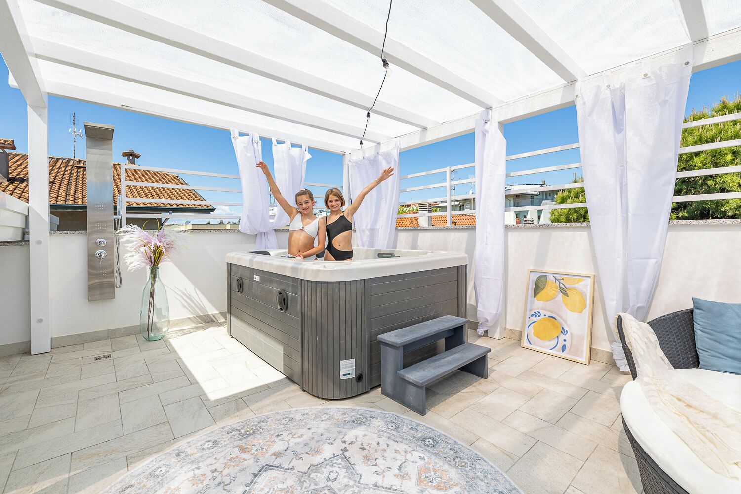 Une terrasse sur le toit avec un jacuzzi, des sièges extérieurs et une vue sur le paysage urbain.