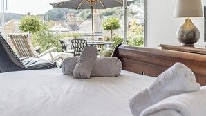 A hotel room with a bed, a view of the outdoors, a table with chairs, and an umbrella. - 1 bedroom accommodation in 3 Coombe Close (3 Coombe Close)