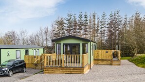 Une rangée de chalets avec une allée en gravier et une voiture garée devant.