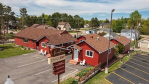 Un bâtiment rouge avec une enseigne indiquant « Vacation Uniquely », proposant des réservations en ligne et un enregistrement autonome.