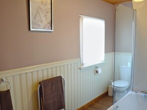 Une salle de bain équipée d’une baignoire, de toilettes et d’un porte-serviettes avec des serviettes.