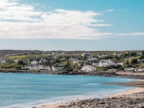 Un pueblo costero con casas blancas, una costa rocosa y un mar azul cristalino.