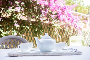 A white teapot, two cups, and a tray on a table with a chair. - La Maison Vintage by Winkyhouse Cassis (Cassis)