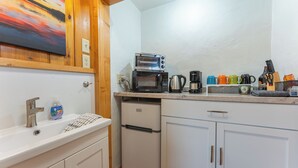 A compact kitchen with a white sink, a small refrigerator, a microwave, and a coffee maker. - Vacation UniquEly cottage #4 (Ely)