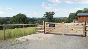A rural property with a wooden gate labeled "Holiday Let" and a view of the countryside. - The Lookout - UK35022 (Hope-under-Dinmore)