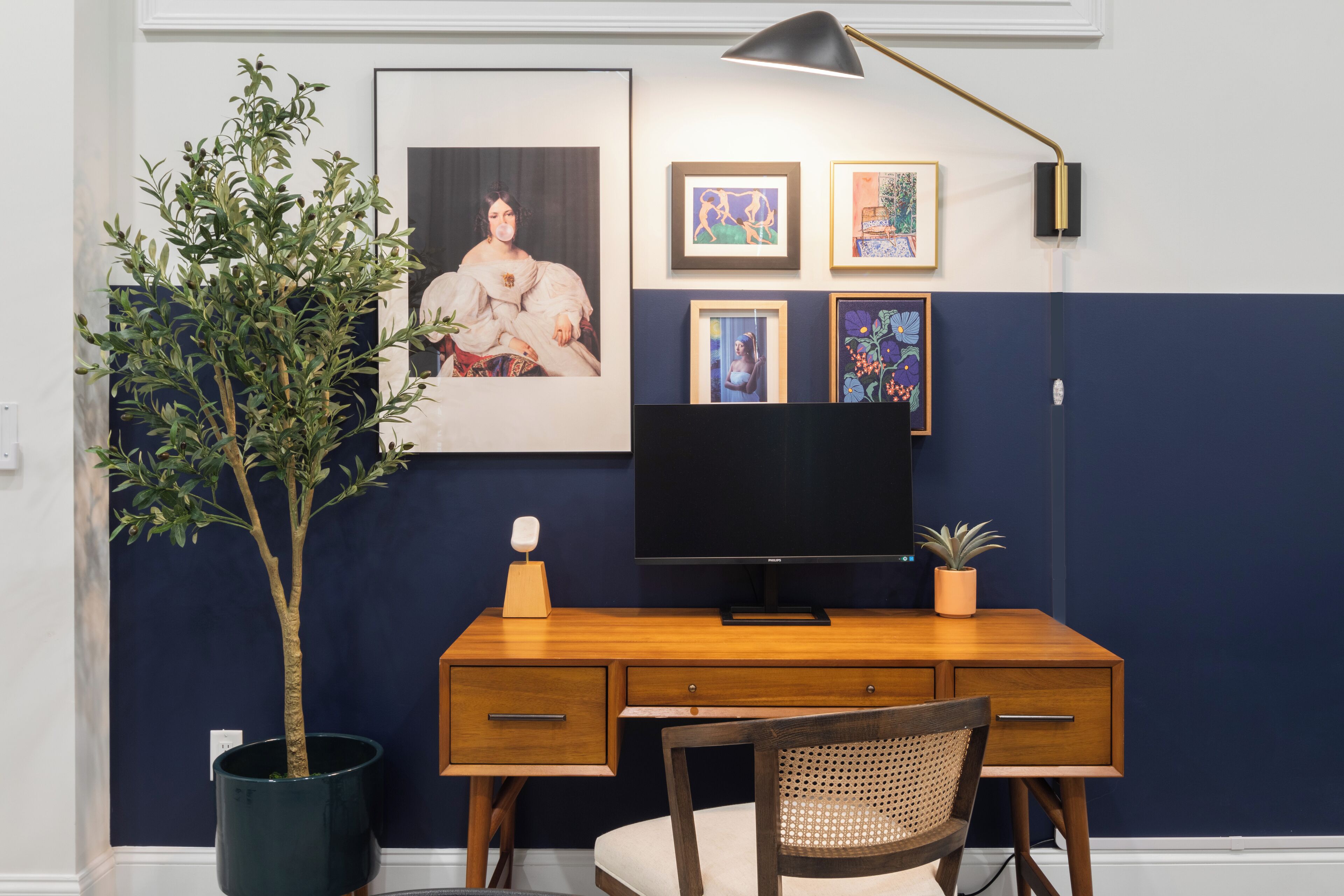 Habitació moderna amb escriptori de fusta, televisió i una planta en test.
