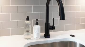 A kitchen sink with a modern faucet and soap dispensers.