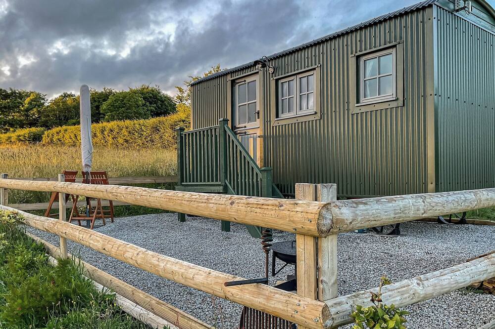 This bespoke shepherds hut is located on a working farm with alpacas and has stunning views.