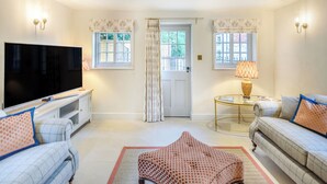 A living room with a flat-screen TV, two sofas, a coffee table, and a patterned rug. - 2 bedroom accommodation in Halton Holegate (Halton Holegate)