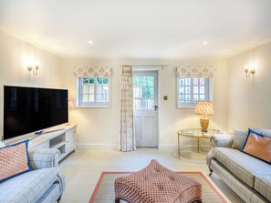 A living room with a flat-screen TV, two sofas, a coffee table, and a patterned rug. - 2 bedroom accommodation in Halton Holegate (Halton Holegate)