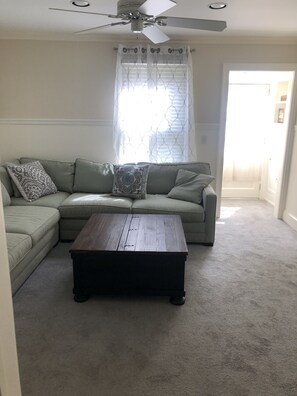 Relax in this inviting living room with a comfortable sofa, coffee table, and ceiling fan.