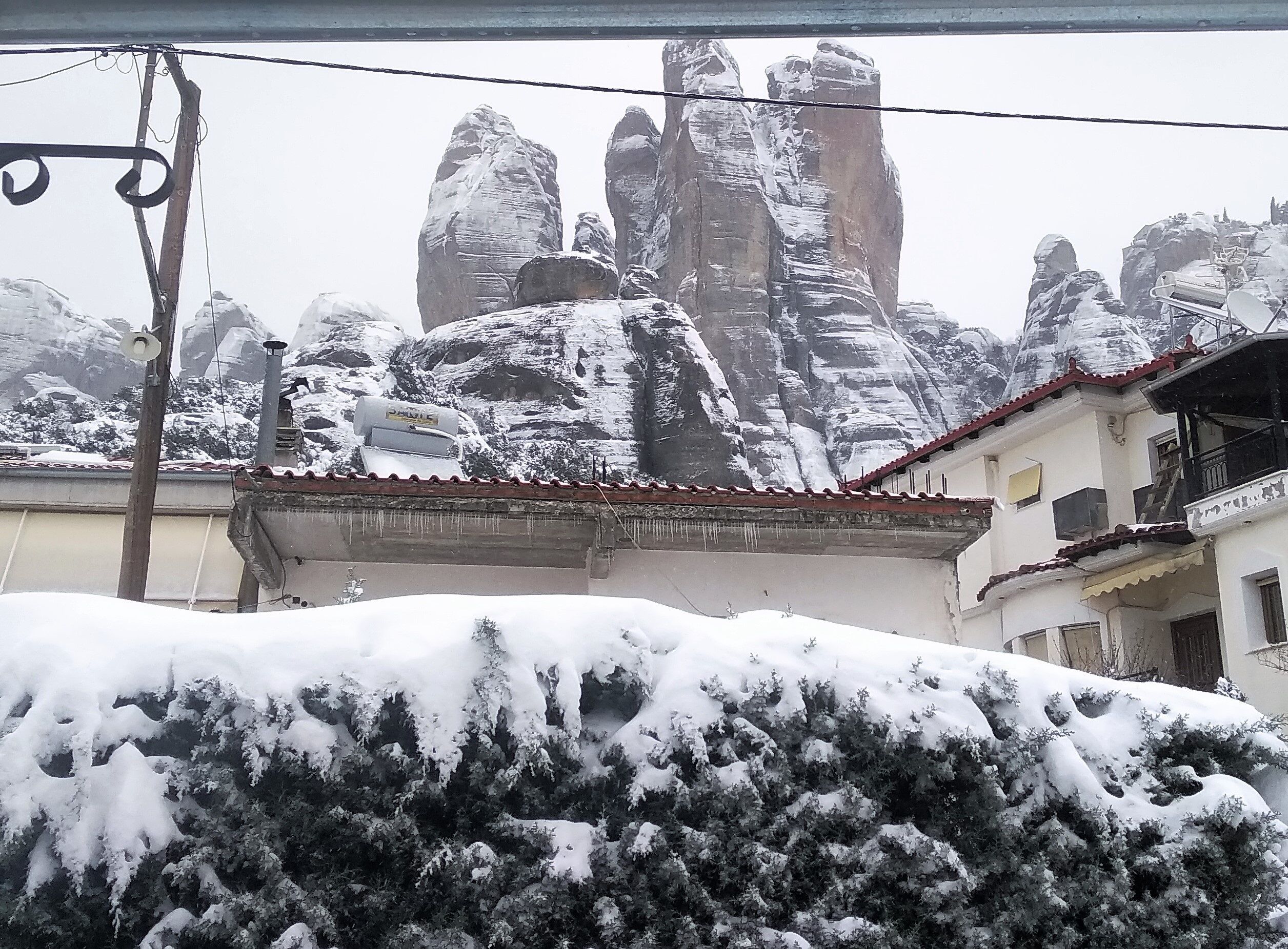 A building with a snow-covered roof and a mountainous backdrop.