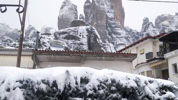 A building with a snow-covered roof and a mountainous backdrop.