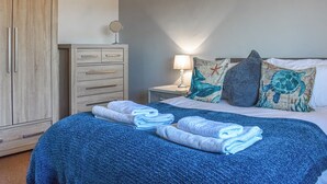 Une chambre à coucher comprenant un lit, une table de chevet, une commode et une armoire.