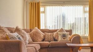 Un salon chaleureux avec un canapé marron, des coussins moelleux et une table basse en bois.