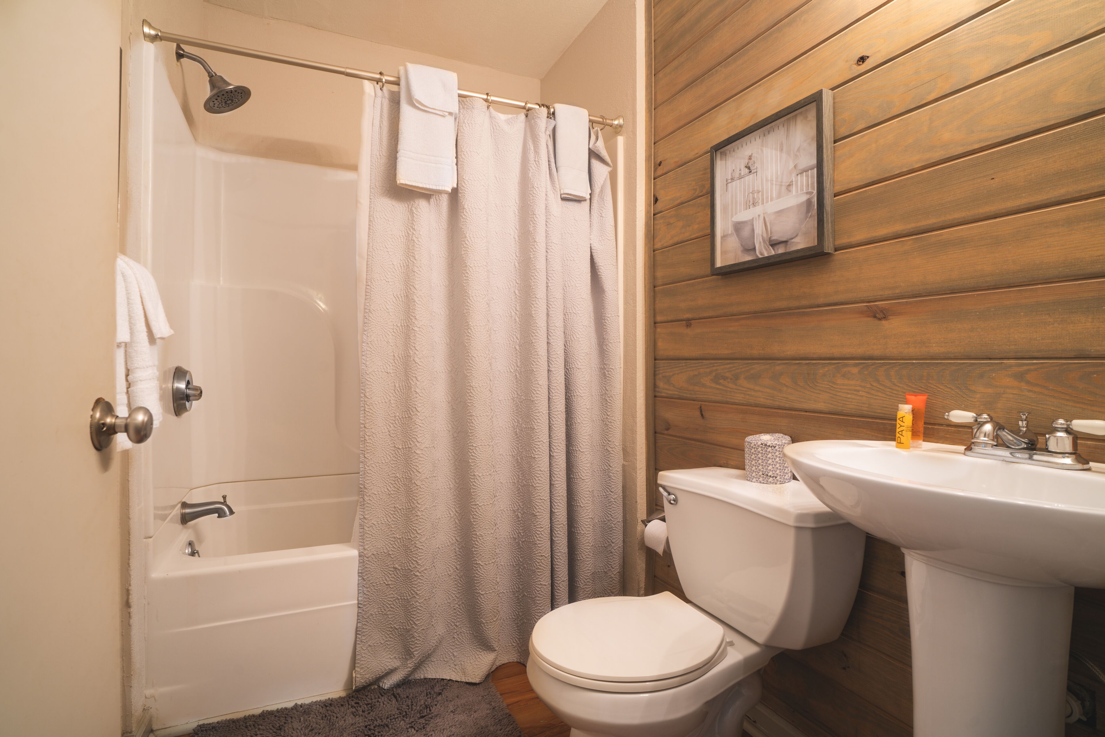 Een badkamer met een bad, toilet en wastafel.