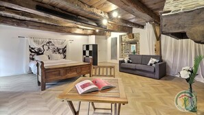 Una camera da letto rustica con un letto di legno, un divano e un tavolo con un libro.