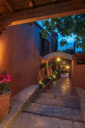 A stone pathway leading to a building with a balcony and an arched entrance. - Hotel Morelia Boutique Villa Italia (Morelia)