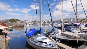 A marina with boats docked, a clear sky, and a calm water surface. - Criccieth holiday apartment is a bolthole for two in a converted church. (Criccieth, near Llyn Peninsula)