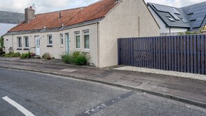 Et toetagers hus med røde tegltage, en hvid dør og et blåt hegn.