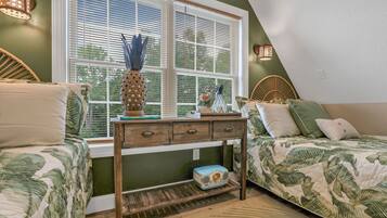 A bedroom with two beds, a nightstand, a window with blinds, and a decorative vase.