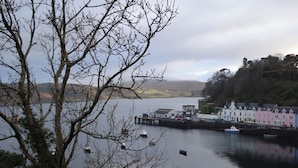 A coastal town with a pier, boats, and colorful buildings along the waterfront. - 2 bedroom accommodation in Portree, Isle of Skye (Portree, Isle of Skye)