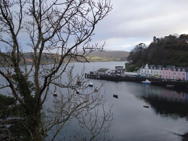 A coastal town with a pier, boats, and colorful buildings along the waterfront. - 2 bedroom accommodation in Portree, Isle of Skye (Portree, Isle of Skye)
