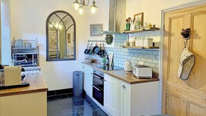 A compact kitchen with a central island, a microwave, a toaster, and a sink.