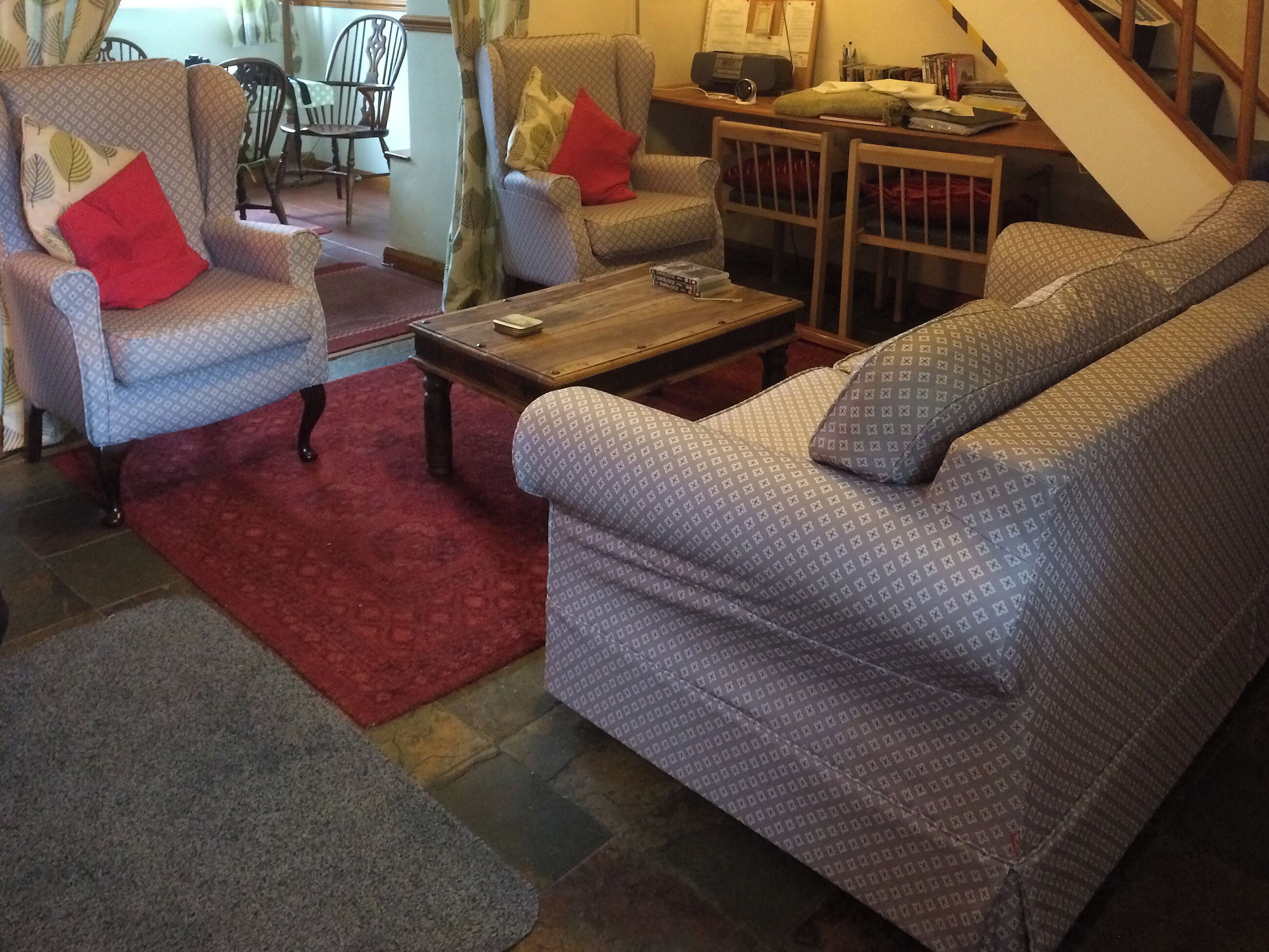 Ein Wohnzimmer mit gestreiften Sofas, einem Couchtisch und einem roten Teppich.