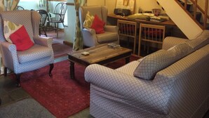 Ein Wohnzimmer mit gestreiften Sofas, einem Couchtisch und einem roten Teppich.