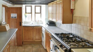 Eine Küche mit Holzausstattung, einem Gasherd, einer Spüle und einem Fenster.