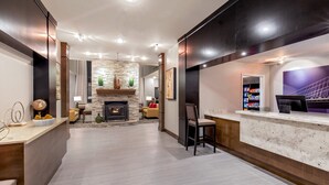 Eine moderne Hotelhalle mit Kamin, Sitzecke und einer Rezeption.