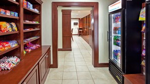 A hotel lobby with a snack bar, a refrigerator stocked with beverages, and a seating area with chairs and a table. - Fully-Equipped Suite |Pool + Wi-Fi (Elkhart)