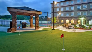 A golf course with a pavilion, a building with multiple windows, and outdoor seating. - Fully-Equipped Suite |Pool + Wi-Fi (Elkhart)