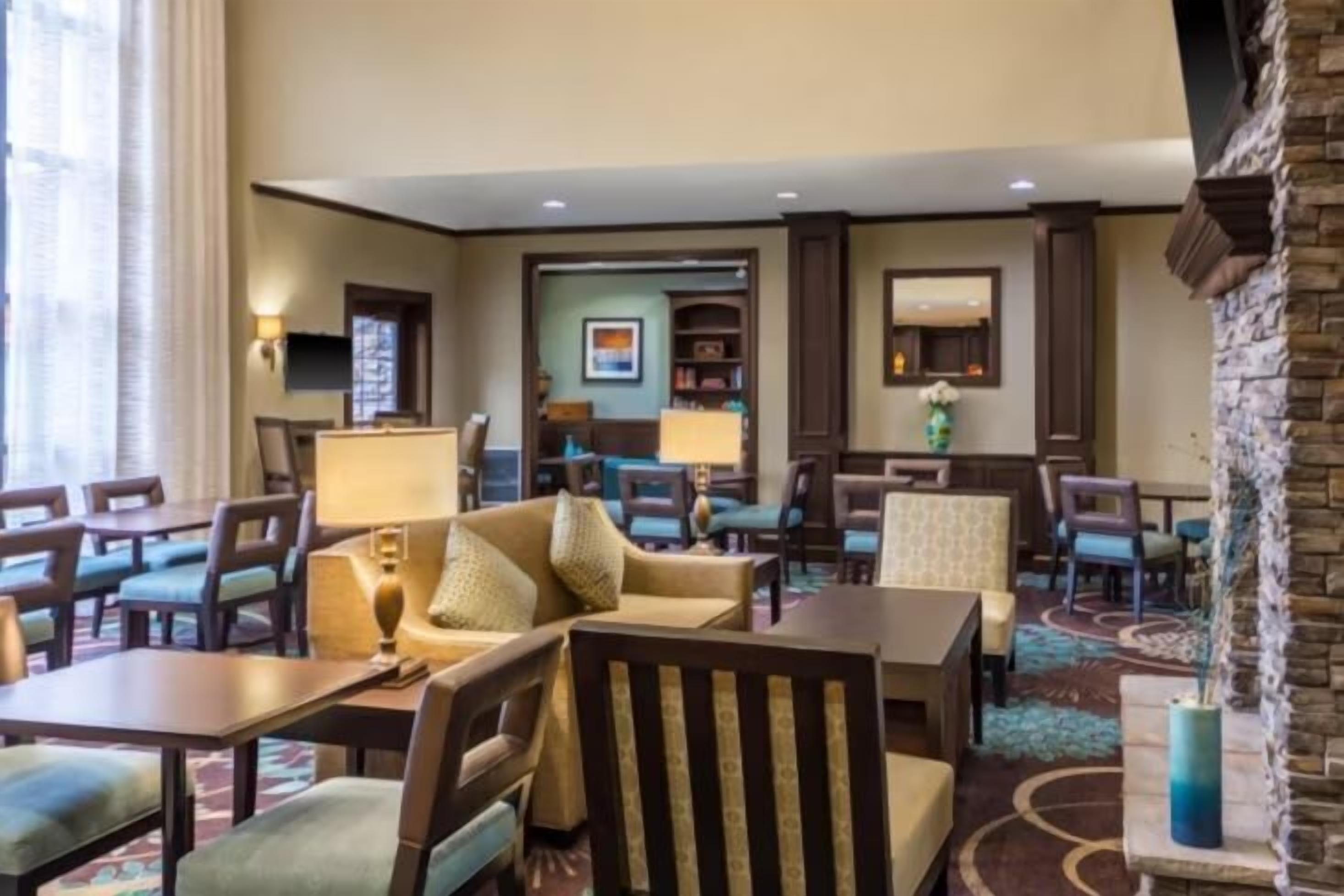 A hotel lobby with a seating area, a reception desk, and a fireplace.