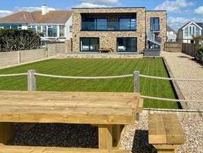 A modern two-story house with a well-maintained lawn, a wooden deck, and a gated entrance. - 6 bedroom accommodation in Elmer (Elmer)