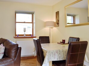 A dining area with a table, chairs, a lamp, a window, and a mirror. - A beautiful barn conversion set within the grounds of a working farm. (Benmore near Dunoon)