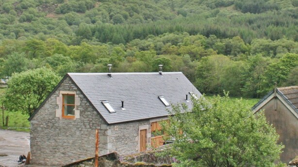 A stone house with a sloped roof, a chimney, and a window. - A beautiful barn conversion set within the grounds of a working farm. (Benmore near Dunoon)